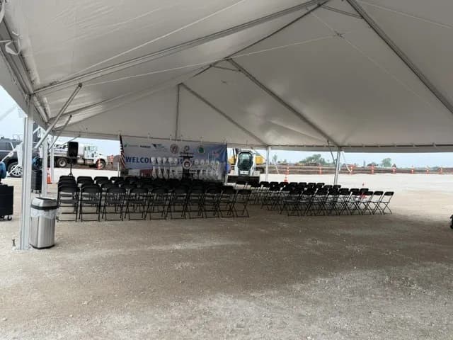 40x60 frame tent rental on a gravel site with folding chairs arranged for a ceremony