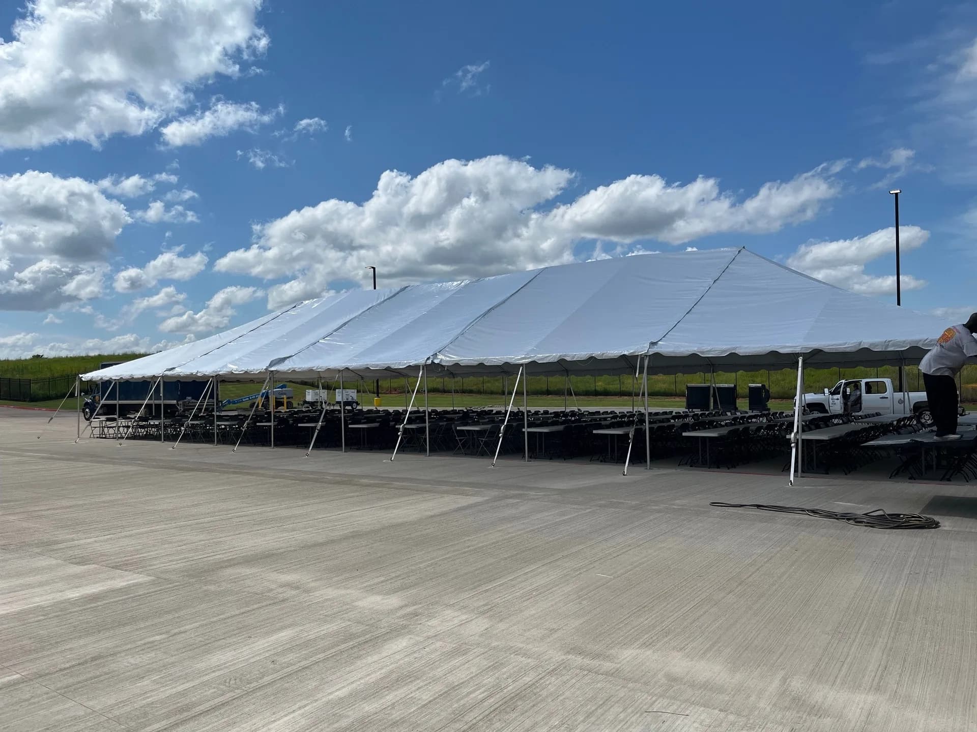 40x100 white frame tent rental with rows of banquet tables and chairs set up for a corporate event in Oklahoma