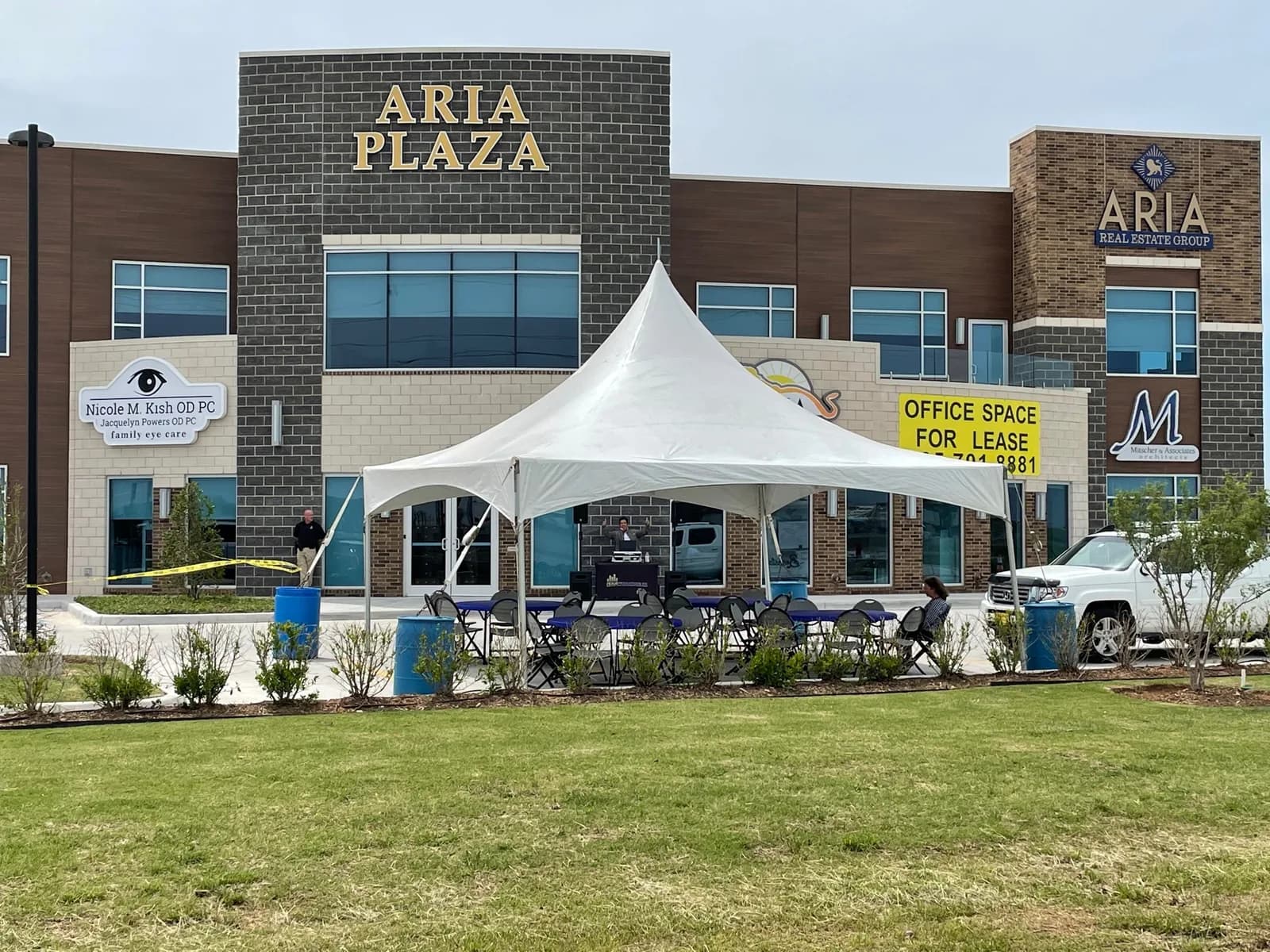 20x20 high peak tent rental set up with tables and chairs outside an Oklahoma City office plaza